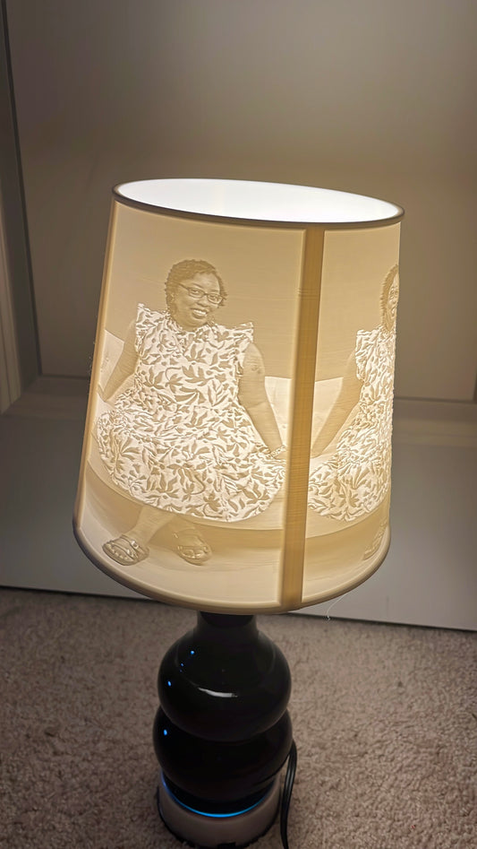 Lamp with a decorative shade featuring a person in a dress. Lamp with a decorative shade featuring a person in a dress.