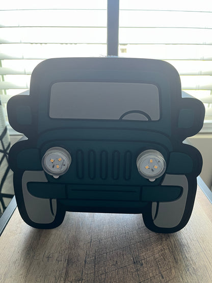 Green car-shaped object on a wooden surface with a blurred background