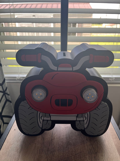 Toy car-shaped object on a wooden surface with a window in the background